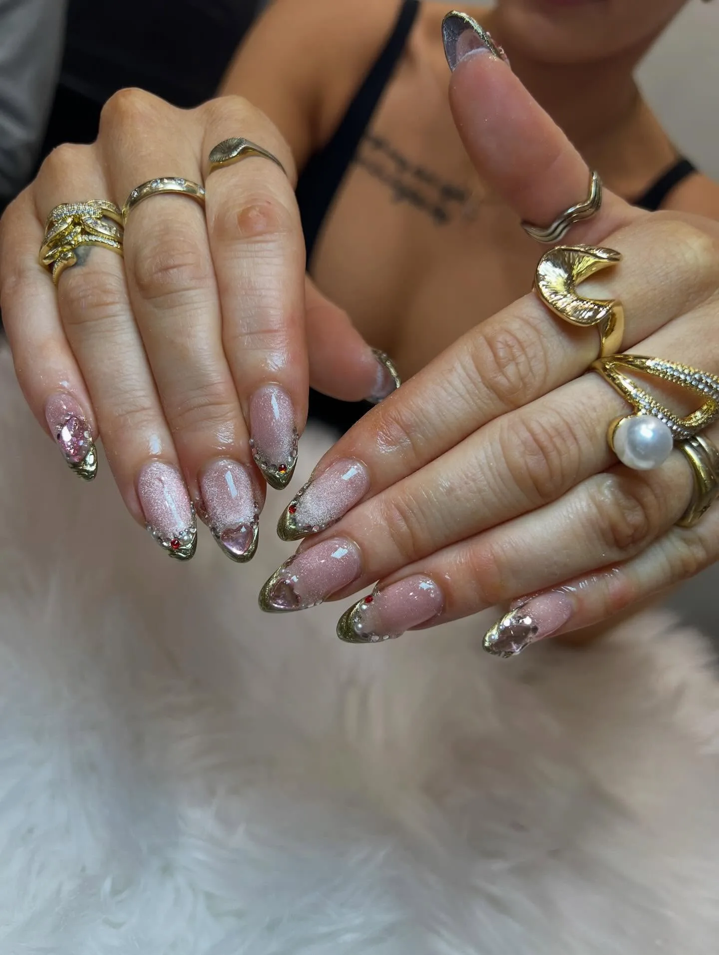 Nude almond nails with silver-gold chrome French tips and red gem hearts