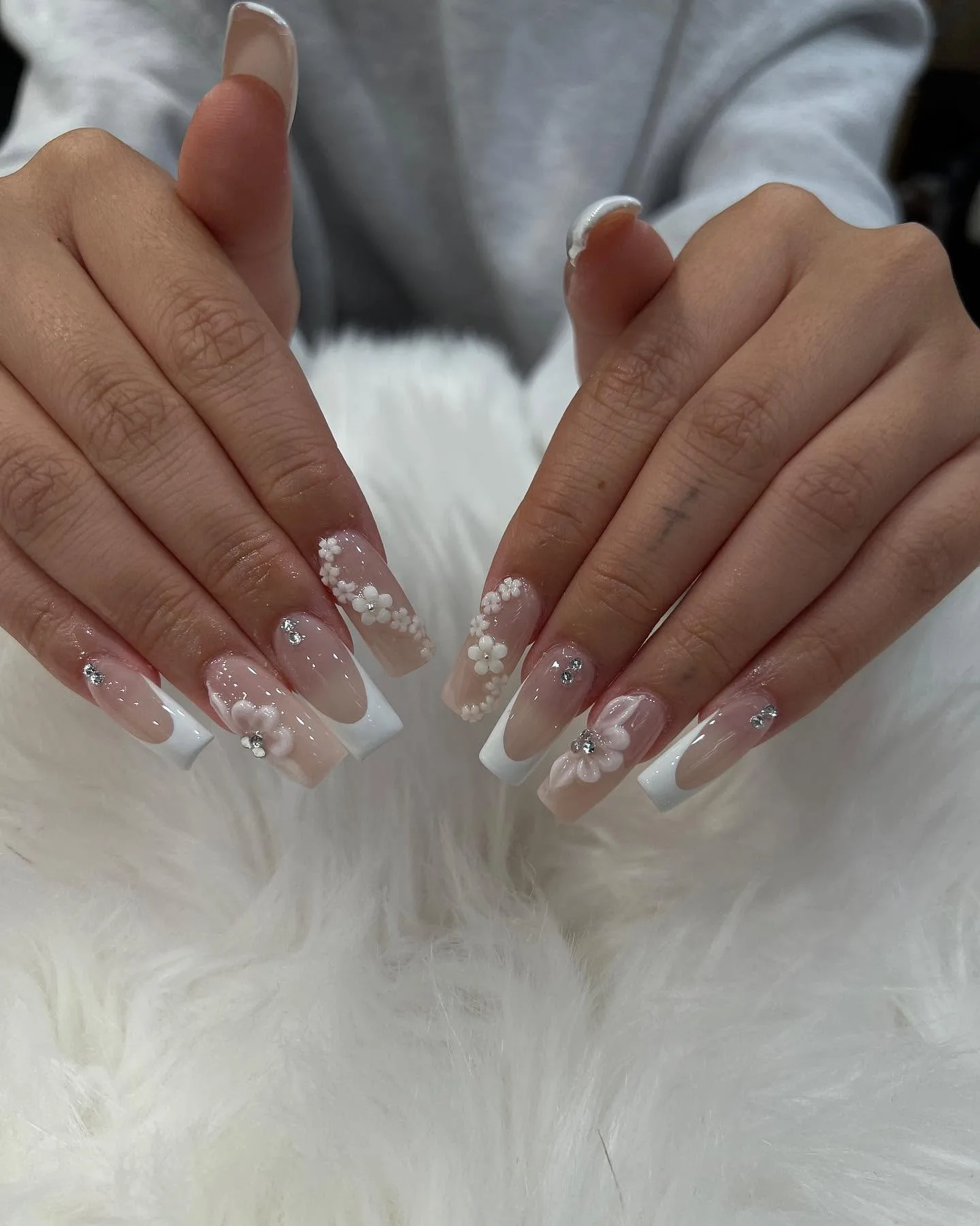 Nude round nails with gold chrome French tips and star-burst gems