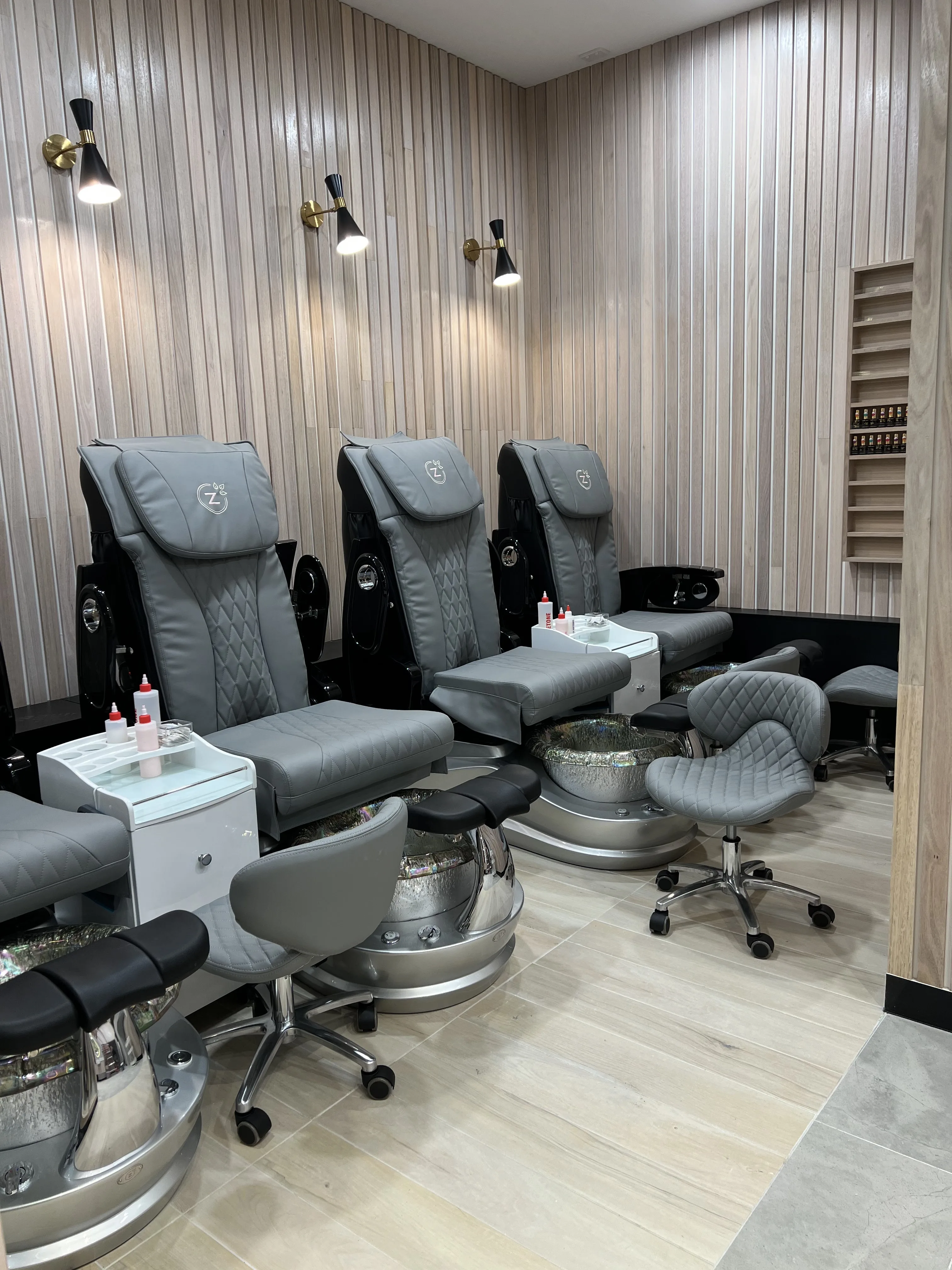 Beauty Genesis Richmond interior — spa-pedicure thrones with chrome basins in a warm pale-timber room