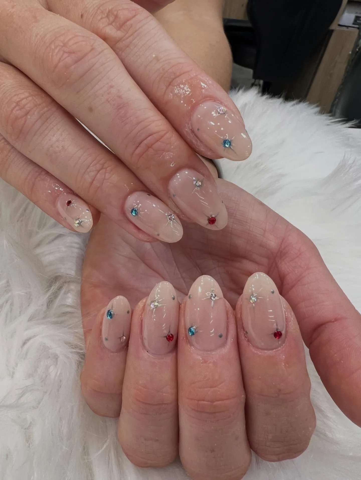 Minimalist nude round nails with scattered coloured gem dots